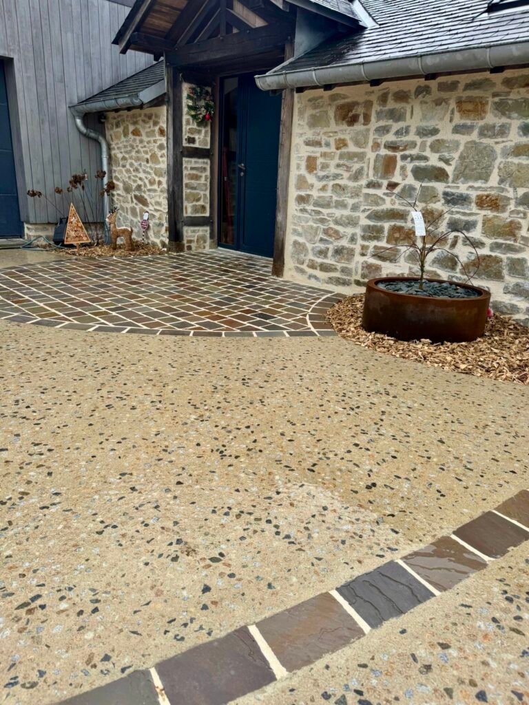 Cour en béton érodé - pavés en grès multicolore - jardinières en corten